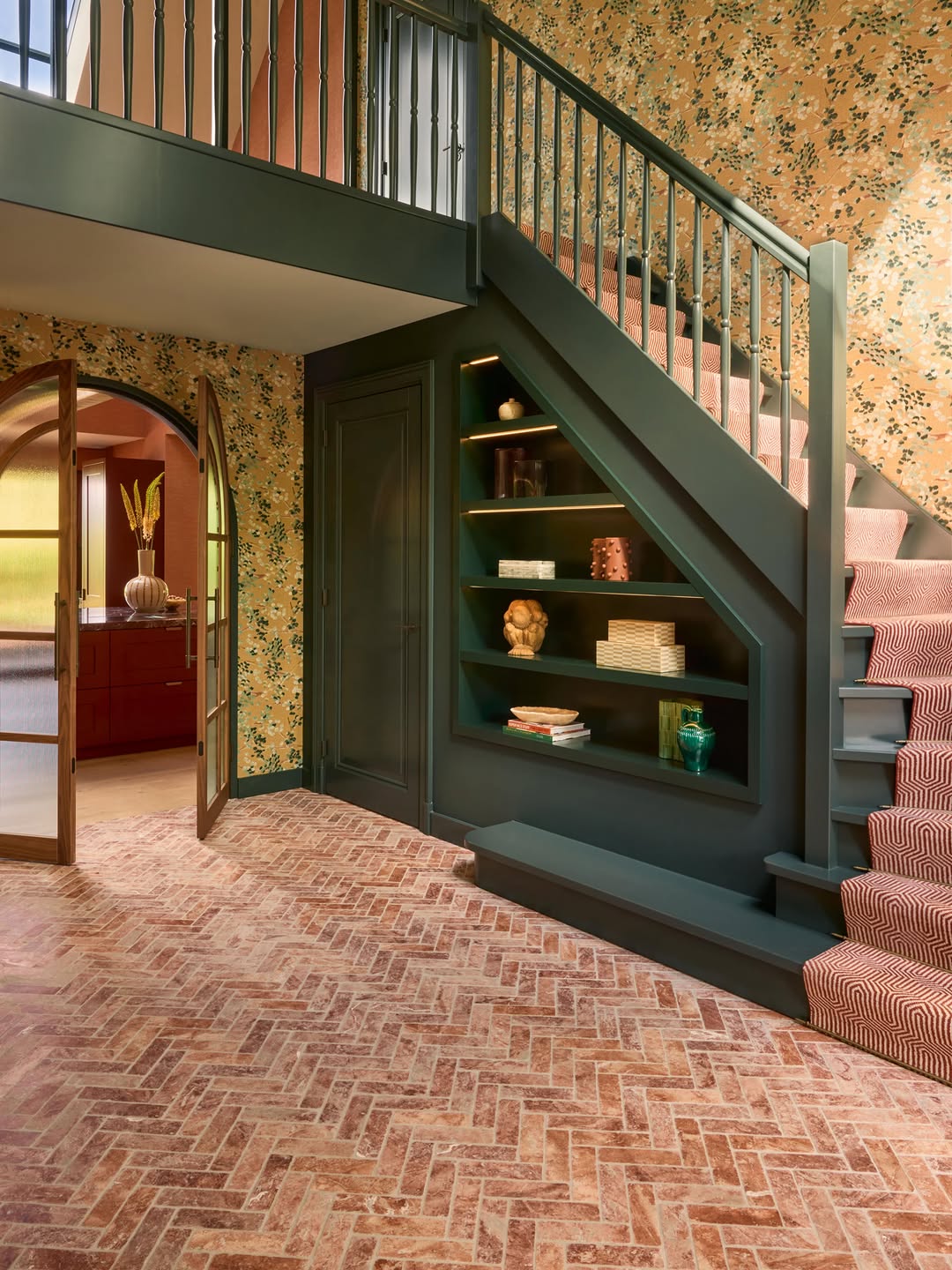 Brick Red Travertine in visgraat in een hal met donkergroene trap, geleverd door Designtegels.nl Utrecht