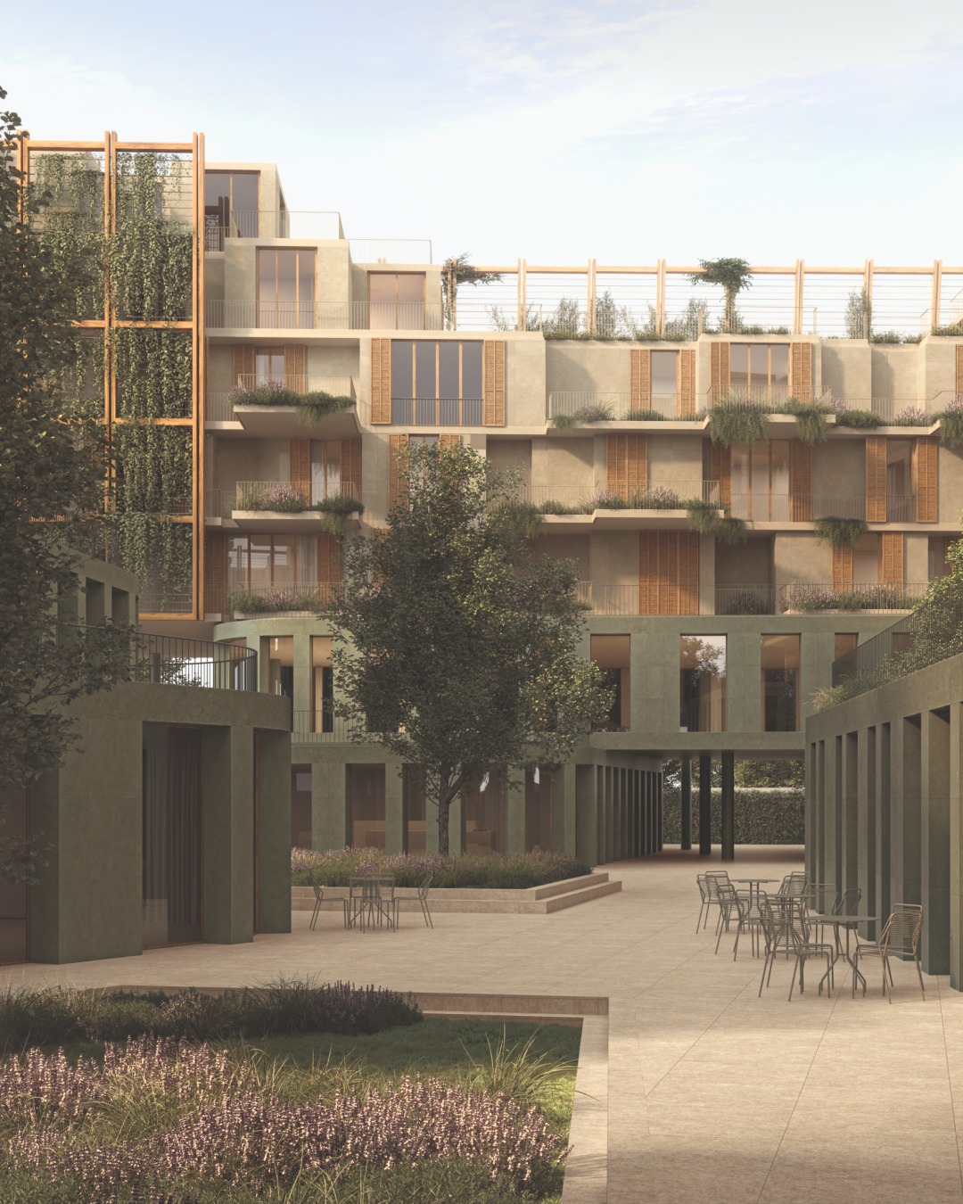 Groene binnenplaats met zandkleurige bestrating, zitplekken en gevels met houtkleurige luiken en beplante balkons.