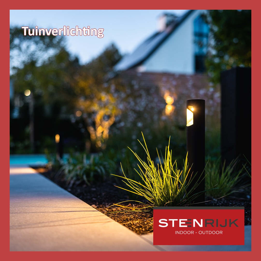 Zwarte tuinlampen verlichten een tuinpad en siergrassen met warm licht, met een uitgelichte boom op de achtergrond.