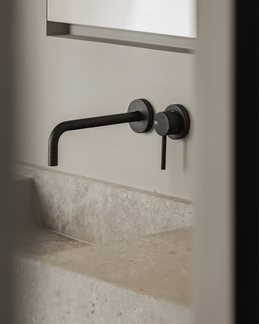 Design Nation Kortrijk: beige wastafel met genuanceerde structuur en donkere wandkraan bij Brachot