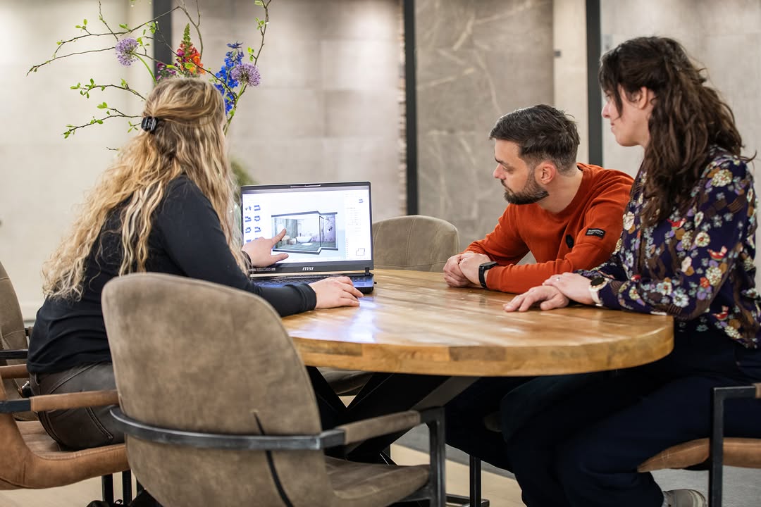 Herfstvakantie bij Tegelhandel van der Rijt Sint Anthonis: adviesgesprek aan tafel met een badkamerontwerp op een laptop
