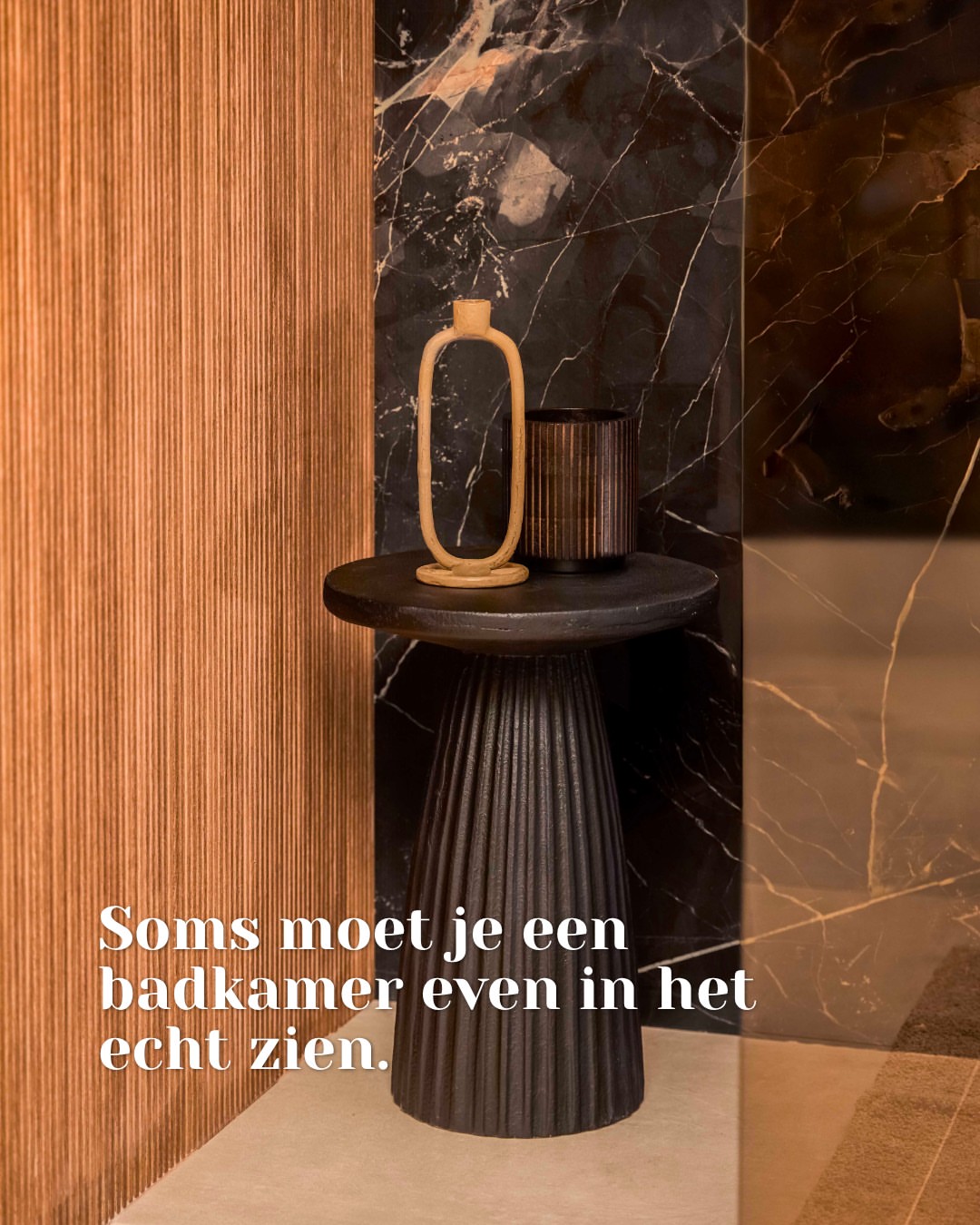 Donkere wandtegels met lichte aders naast een geribbelde wand bij Zoon Tegels & Badkamers in Heemskerk