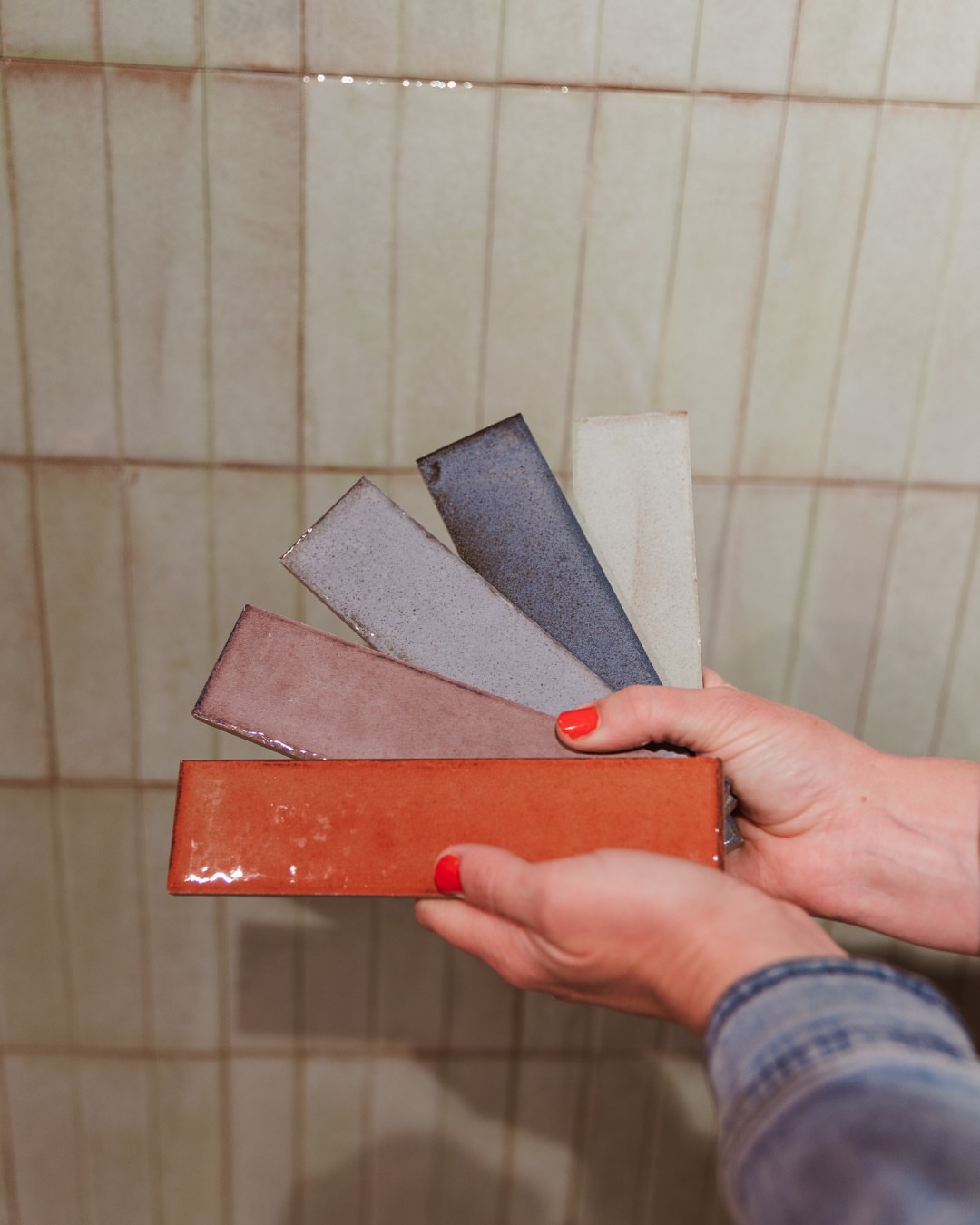 Glanzende wandtegels als kleurrijke langwerpige stalen voor een lichte tegelwand bij Van der Rijt Tegels Uden
