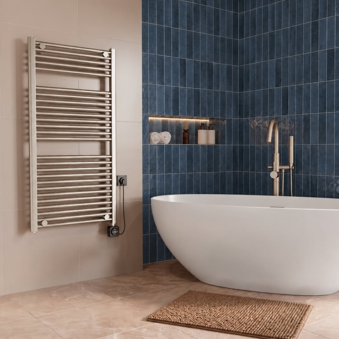 Elara radiator aan een beige tegelwand naast een vrijstaand wit bad en diepblauwe wandtegels.